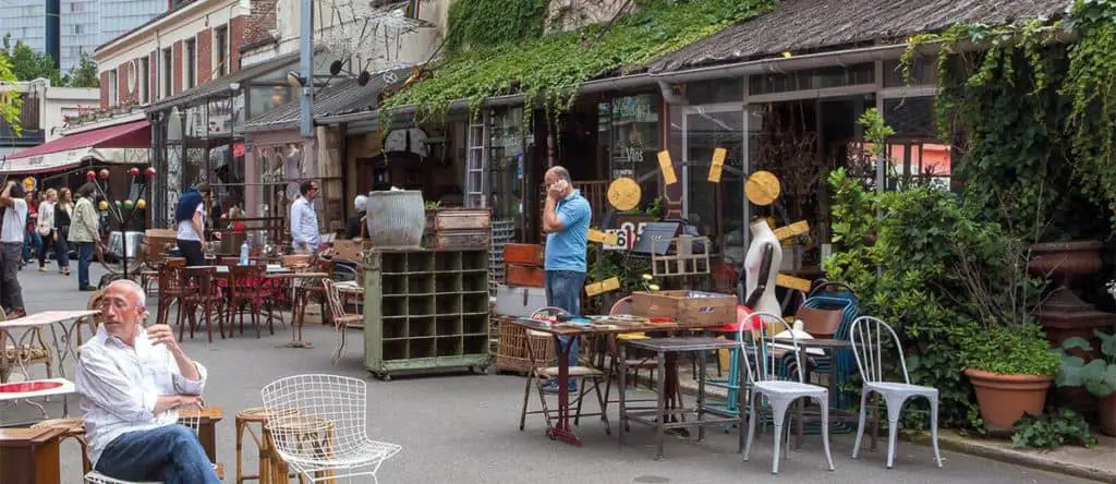 flea market merchants sitting outside their shop in st ouen flea market