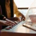 two kids playing an electronic keyboard together