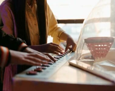 two kids playing an electronic keyboard together